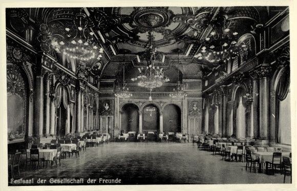 Schwarzes und weißes Foto eines großen Raumes mit Tischen, Stühlen, Säulen, Bögen und Kronleuchtern, beschriftet mit "Festival der Gesellschaft der Freunde, Berlin" unten.