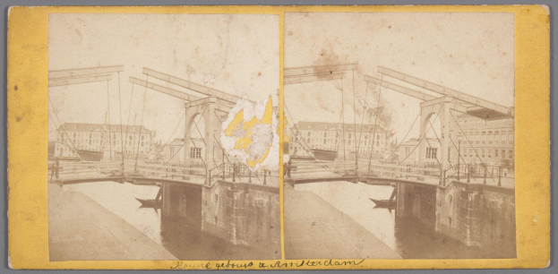 Ein altes Foto einer Brücke, die über ein Gewässer führt und im Hintergrund Gebäude zeigt, mit Anzeichen von Reparaturen und verstreuten Werkzeugen und Materialien.