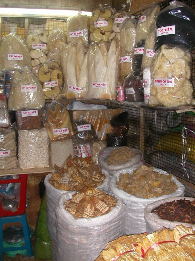 Ein gut organisierter Marktstand mit ordentlich sortierten Lebensmitteln in Tüten und Plastikhauben.