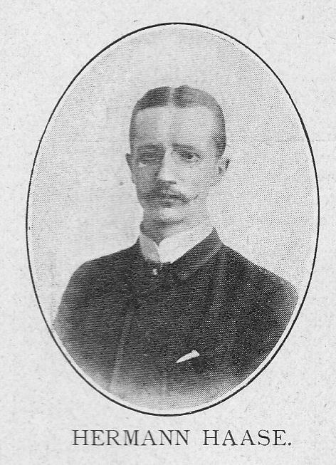 Schwarz-weiß-Porträt des deutschen Komponisten und Pianisten Hermann Haase in einem Anzug mit Schnurrbart, ernster Miene und deutschem Text unten.