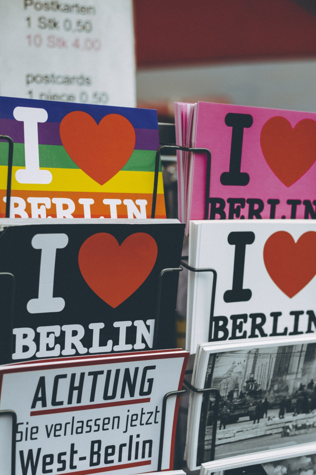 Ein Gestell mit Büchern und Plakaten mit der Aufschrift "Ich liebe Berlin" vor einem leicht unscharfen, verträumten Hintergrund.