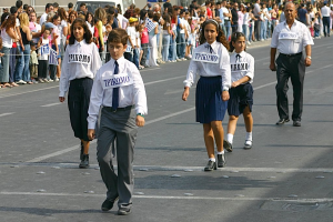 Menschen auf einer Straße bei einem Ereignis, die Abzeichen tragen und von einer großen Menge umgeben sind.