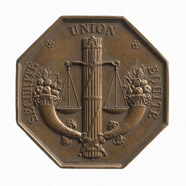 Bronzene Medaille mit der Aufschrift "Securite Union Equite" auf weißem Hintergrund.