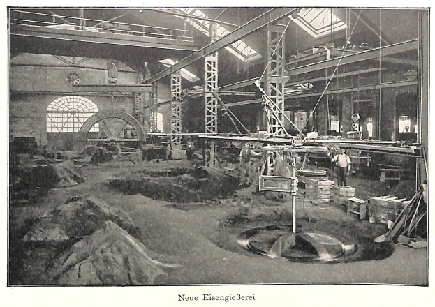 Schwarzes und weißes Foto einer Fabrikhalle mit Arbeitern an Maschinen, Metallstangen und Pfählen, beschriftet mit "Neue Eisenglebeerei, die erste Fabrik Deutschlands" unten.