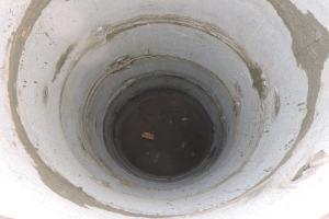 Betonschalung mit mittiger Öffnung in einer Betonwand und einem Objekt innerhalb des Rohrs.