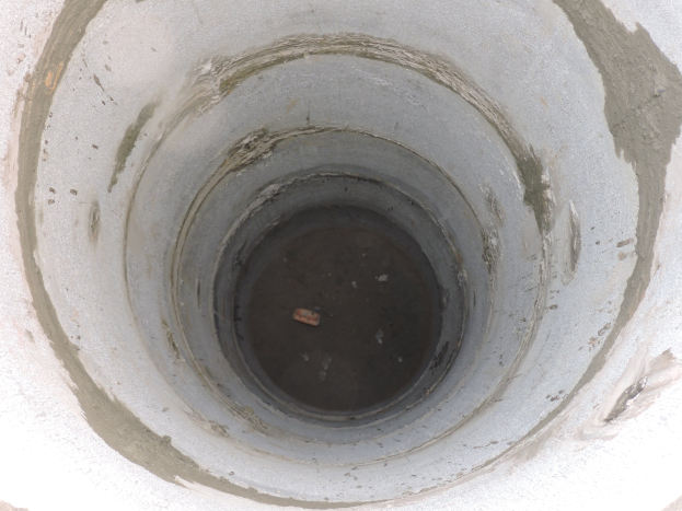 Betonschalung mit mittiger Öffnung in einer Betonwand und einem Objekt innerhalb des Rohrs.