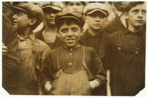 Schwarzes und weißes Foto einer Gruppe junger Jungs, die zusammenstehen, jeder trägt eine Mütze.